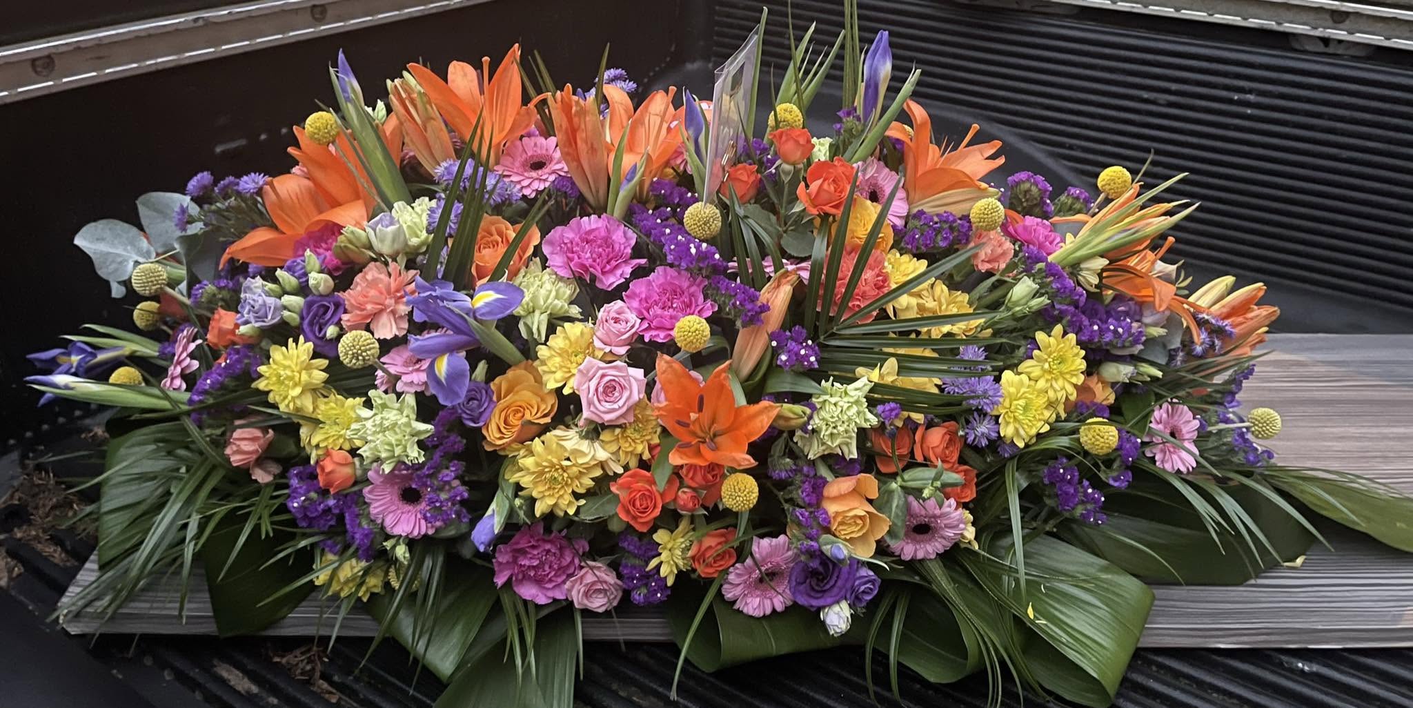 Colourful rainbow casket spray